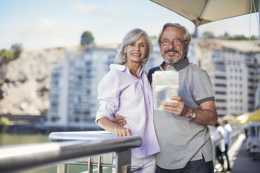 Senior couple taking a city break, holding map - ZEF14149