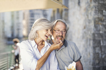 Senior couple taking a city break, eating French fries - ZEF14159