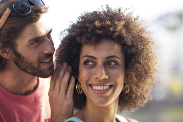 Happy young couple, man whispering into woman's ear - ZEF14186