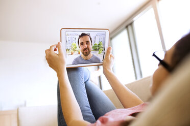 Junge Frau benutzt Tablet für Videochat zu Hause - HAPF01892