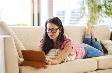 Junge Frau benutzt Tablet für Videochat zu Hause - HAPF01897