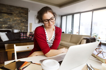 Portrait of smiling sitting at desk at home - HAPF01904