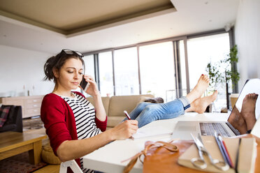 Frau am Telefon bei der Arbeit am Schreibtisch zu Hause - HAPF01909