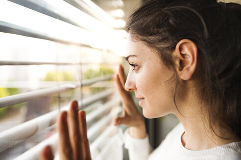 Frau zu Hause mit Blick aus dem Fenster - HAPF01942