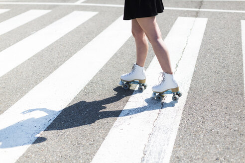 Young woman with roller skates on zebra crossing, partial view - JPF00249