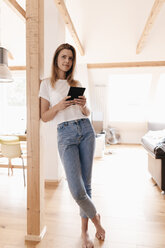 Junge Frau zu Hause mit digitalem Tablet - GUSF00107