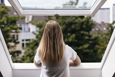 Junge Frau schaut aus dem Fenster - GUSF00116