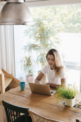 Junge Frau zu Hause am Laptop - GUSF00117