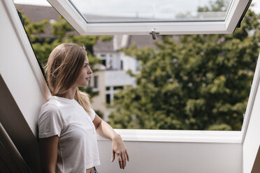 Junge Frau schaut aus dem Fenster - GUSF00118