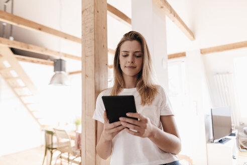 Junge Frau zu Hause mit digitalem Tablet - GUSF00138