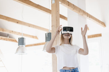 Young woman wearing VR goggles, designing her new home - GUSF00140