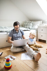 Father at home with his little son using laptop - HAPF01946