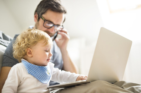 Father with his little son working from home stock photo