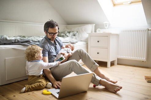 Father with his little son and baby daughter working from home - HAPF01981