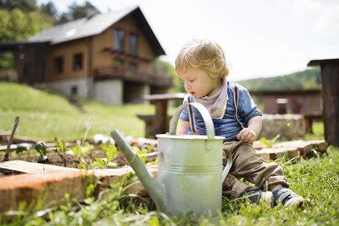 Junge im Garten mit Gießkanne, lizenzfreies Stockfoto