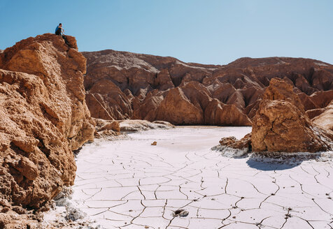 Chile, Atacama-Wüste, Mann sitzt auf einem roten Felsen und betrachtet die Aussicht - GEMF01741
