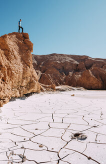 Chile, Atacama-Wüste, Mann steht auf einem roten Felsen und betrachtet die Aussicht - GEMF01742
