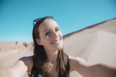 Chile, Atacama-Wüste, Porträt einer lächelnden Frau, die ein Selfie macht - GEMF01743