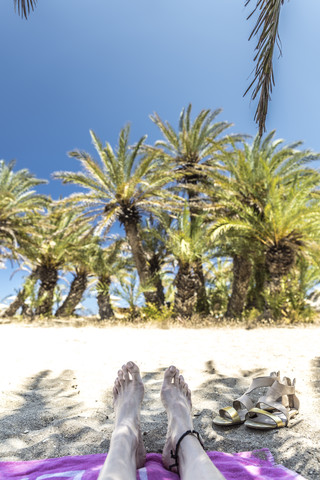 Griechenland, Kreta, Vai, Füße einer Frau beim Entspannen am Strand, lizenzfreies Stockfoto