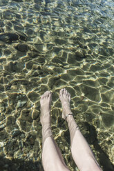 Beine einer Frau im flachen Meerwasser - CHPF00415
