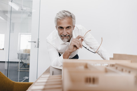 Mature businessman examining architectural model in office stock photo