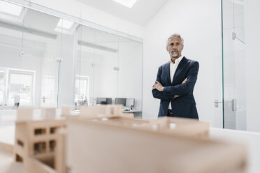 Älterer Geschäftsmann mit Architekturmodell im Büro - KNSF02125