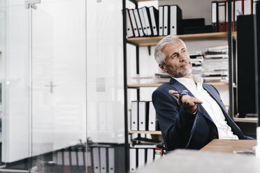 Mature businessman in office with fidget spinner - KNSF02133