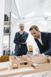 Zwei Geschäftsleute prüfen ein Architekturmodell im Büro - KNSF02143