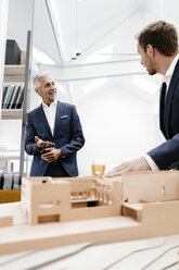 Zwei Geschäftsleute mit Architekturmodell im Büro - KNSF02145