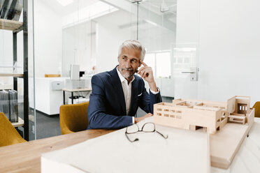 Älterer Geschäftsmann mit Architekturmodell im Büro - KNSF02150