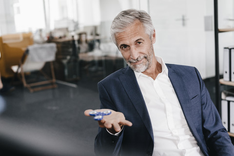 Porträt eines reifen Geschäftsmannes im Büro mit Zappelphilipp, lizenzfreies Stockfoto