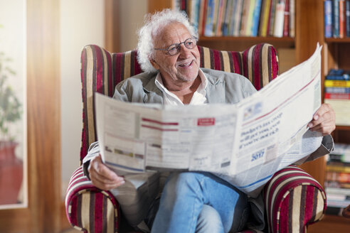 Älterer Mann sitzt in der Bibliothek und liest Zeitung - ZEF14200