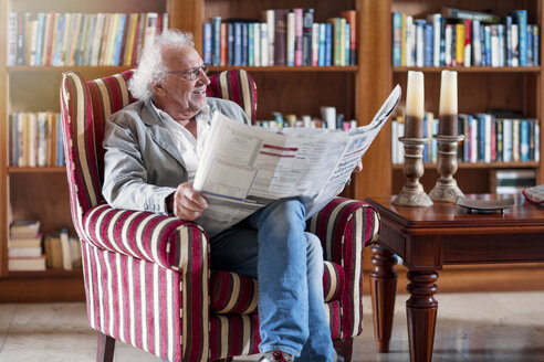 Älterer Mann sitzt in der Bibliothek und liest Zeitung - ZEF14201