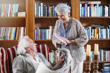 Älterer Mann und Frau sitzen in der Bibliothek und lesen Buch und Zeitung - ZEF14202