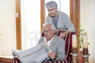 Älterer Mann und Frau sitzen in der Bibliothek und lesen Zeitung - ZEF14205