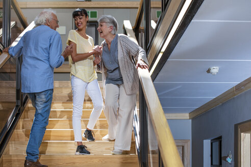 Nurse helping laughing seniors on staircase - ZEF14230