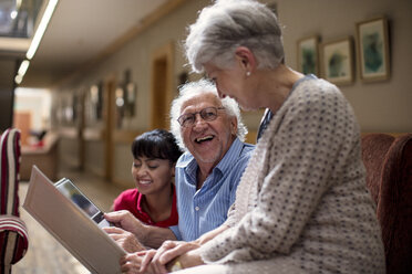 Nurse teaching seniors in retirement home, how to use laptop - ZEF14236