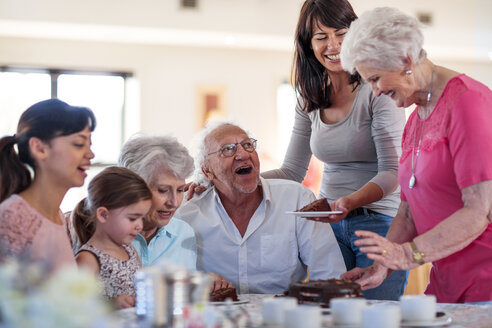 Grandparents celebrating a birthday with their granddaughter, eating chocolate cake - ZEF14256