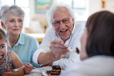 Großeltern feiern mit ihrer Enkelin einen Geburtstag und essen Schokoladenkuchen - ZEF14267