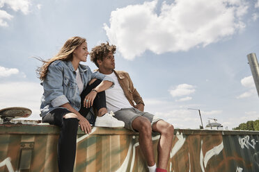 Young couple sitting on a wall - SUF00253