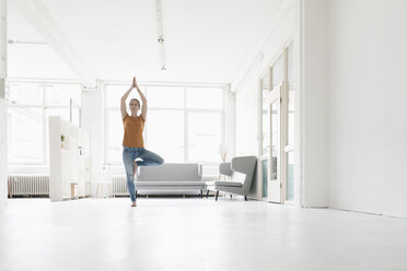 Woman practising yoga in a loft - KNSF02234