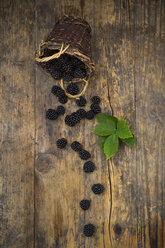 Wickerbasket of organic blackberries and leaves on wood - LVF06237