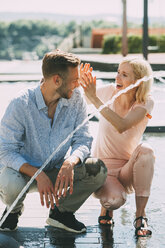 Young couple having fun at fountain - CHAF01931