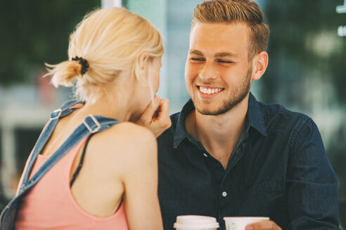 Porträt eines glücklichen jungen Mannes, der mit seiner Freundin Kaffee trinkt - CHAF01932