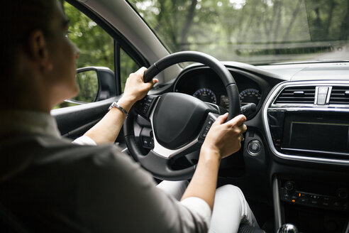 Back view of woman driving car - MOMF00184