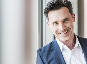 Portrait of smiling businessman with stubble - UUF11229