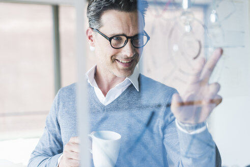 Geschäftsmann berührt die transparente Projektionsfläche im Büro - UUF11239