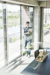 Geschäftsmann beim Lesen von Dokumenten in einem Büro - UUF11245