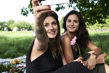 Friends taking smartphone selfies in the park - IGGF00043