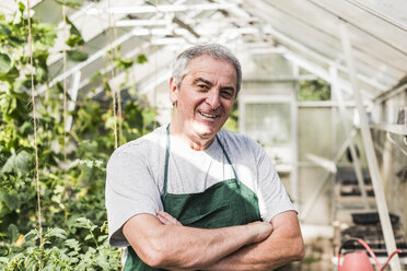 Portrait of smiling senior man in greenhouse - UUF11296
